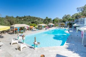 uma grande piscina com cadeiras e guarda-sóis em Paco's Resort Luxury House 16 em Oziás