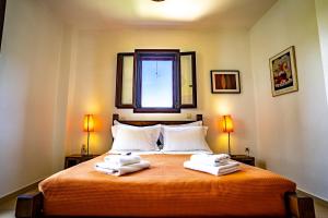 een slaapkamer met 2 handdoeken op een bed met een raam bij Chara House in Skoutarion