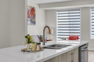 Una cocina blanca con fregadero y ventana. en Luxury Newly Build 4BR House in Oakville, en Oakville