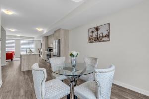 Un comedor con una mesa de cristal y sillas. en Luxury Newly Build 4BR House in Oakville, en Oakville
