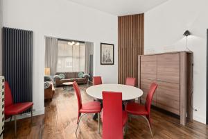 uma sala de estar com uma mesa e cadeiras vermelhas em Kolonel - Charmant & lichtrijk app aan zee 4p em Blankenberge