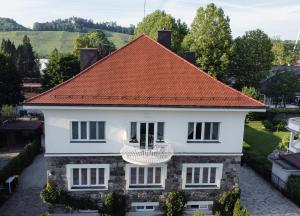 una casa blanca con techo naranja en Luxury Apartment Villa Černigoj en Maribor