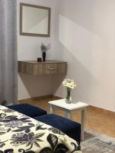 Cette chambre comprend un lit et une table avec un vase de fleurs. dans l'établissement Bella Vista, à Shkodër