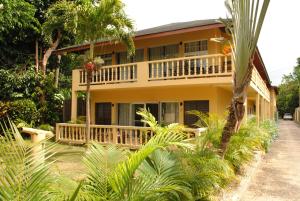 a house with a balcony and palm trees at Moonrisevillas in Negril