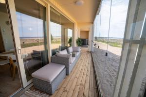 un salon avec un canapé, des chaises et des fenêtres dans l'établissement Marina Resort C1, à Kalajoki