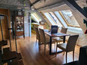 - une salle à manger avec une table, des chaises et un ordinateur portable dans l'établissement Waldblick, à Neustadt an der Weinstraße