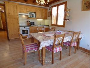 a kitchen with a wooden table and chairs at Charmant appart. 70m², 2 chambres, mezzanine, balcon sud, garage, près commerces, navettes - FR-1-458-110 in Le Grand-Bornand +7 photos