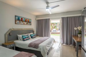 a bedroom with two beds and a window at Beach Cabanas in Jeffreys Bay +24 photos