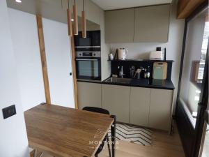uma pequena cozinha com mesa e bancada em Studio Le Grand-Bornand, 1 pièce, 4 personnes - FR-1-458-159 em Le Grand-Bornand
