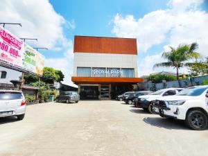 ein Parkplatz mit Autos, die vor einem Autohaus geparkt sind in der Unterkunft Royal Park Hotel in Samarinda