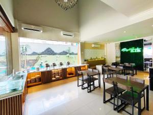restauracja ze stołami i krzesłami oraz dużym oknem w obiekcie Royal Park Hotel w mieście Samarinda