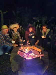 um grupo de pessoas sentadas em torno de uma fogueira em Casa Oma Loni em Pomerode