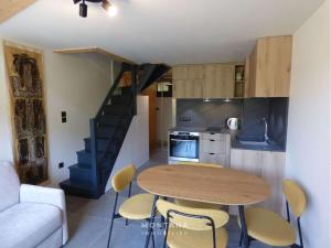 kuchnia i jadalnia ze stołem i krzesłami w obiekcie Appart rénové 2* pour 6 pers. avec 2 salles d'eau et balcon sud - FR-1-458-178 w mieście Le Chinaillon +7 zdjęć