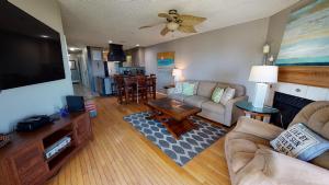 un soggiorno con divano e TV a schermo piatto di Sandcastle Beach Club Unit 4 by Tybee Vacation Rentals a Tybee Island Altre 40 foto