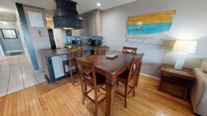 una cucina e un soggiorno con tavolo e sedie in legno di Sandcastle Beach Club Unit 4 by Tybee Vacation Rentals a Tybee Island
