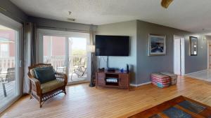 un soggiorno con sedia e TV a schermo piatto di Sandcastle Beach Club Unit 4 by Tybee Vacation Rentals a Tybee Island