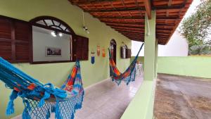 une pièce avec des hamacs sur le côté d'un bâtiment dans l'établissement Cantinho da Cake, à Araruama