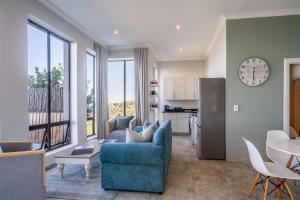 a living room with a blue couch and a kitchen at Knysna Views - Pezula Seashore - Sea-facing in Knysna