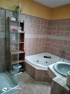 un baño con bañera y ducha de cristal en Chalet vacacional, en El Puerto de Santa María