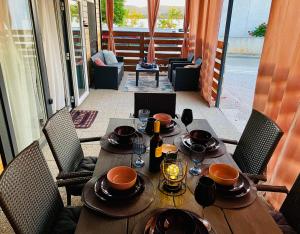 a wooden table with plates and wine glasses on it at TaJa Vortex in Turanj