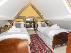 two beds in a room with a red rug at Pentre Hall in Oswestry
