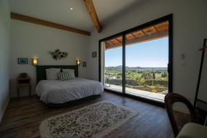 Un dormitorio con una cama y una ventana grande. en Villa Carmen Écrin de Lumière en Provence, en Laouque