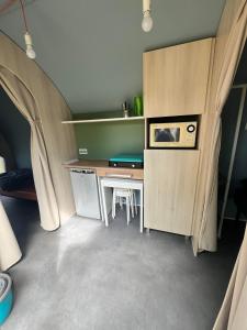 pokój z biurkiem i stołem w pokoju w obiekcie Camping Le Convivial w mieście Foncène