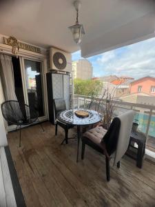 un soggiorno con tavolo e sedie e un balcone di Superbe Appartement 2 chambres terrasse 4 à 6 couchages piscine à deux pas des plages et du centre ville a Cannes