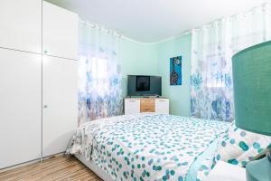 1 dormitorio con 1 cama y TV en Apartments Villa Rudi, en Bibinje