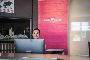 a woman sitting at a table with a laptop at Best Western Hotel Windorf in Leipzig