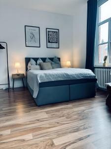 1 dormitorio con 1 cama y suelo de madera en FeWo Burgquartier, en Bad Bentheim