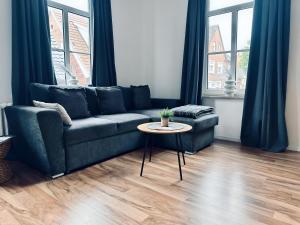 a living room with a blue couch and a table at FeWo Burgquartier Ritterlich & Zentral in Bad Bentheim