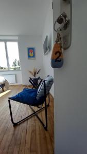 a room with a chair in front of a refrigerator at La Demoiselle in Les Ponts-de-Cé