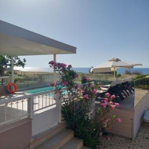Magnisía的住宿－Bella Vista House，一个带游泳池、椅子和鲜花的庭院