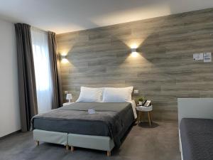 a bedroom with a bed and a wooden wall at Boutique Hotel Nuovo Cason in Cavallino-Treporti