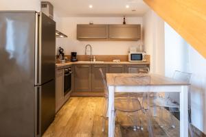 a kitchen with a table and a stainless steel refrigerator at Duplex en plein centre in Propriano