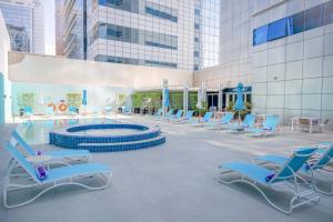 um grupo de cadeiras e uma piscina num edifício em Premier Inn Abu Dhabi Capital Centre em Abu Dhabi