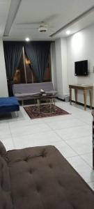 a living room with a bed and a table at Vaporium 2 bedroom Apartment in Rawalpindi