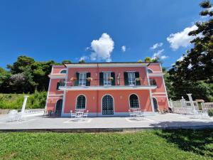 a pink house with tables and chairs in front of it at VILLA ESMERALDA in Salerno