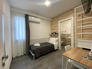 a small room with a bed and a mirror at Boutique Hotel Nuovo Cason in Cavallino-Treporti