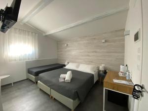 a hotel room with two beds and a desk at Boutique Hotel Nuovo Cason in Cavallino-Treporti