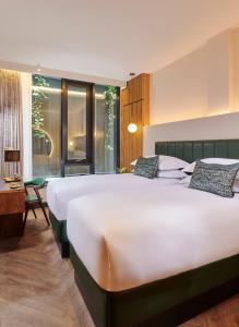 Un dormitorio con una gran cama blanca y una ventana en The Chancery Hotel en Dublín