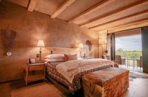 a bedroom with a bed and a large window at Kapama River Lodge in Kapama Private Game Reserve