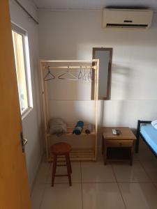 a room with a bed and a stool and a mirror at Apto 4 ótimo local próximo shopping in Campo Grande