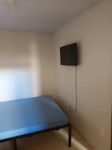 a room with a bed and a tv on a wall at Apto 4 ótimo local próximo shopping in Campo Grande