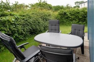 a table and chairs sitting on a patio with a table and four chairs at Möve Aba Bungalow 65 in Rerik