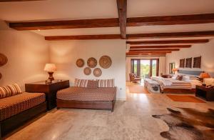 uma grande sala de estar com duas camas e um sofá em Kapama River Lodge em Reserva de Caça Kapama
