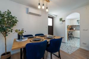 a dining room with a wooden table and blue chairs at Duplex apartment Domi in Slatine
