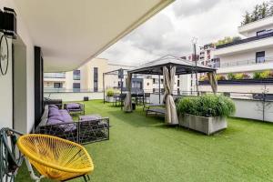 eine Terrasse mit Stühlen und einem Sonnenschirm auf dem Balkon in der Unterkunft Bed and Breakfast Nimrod Boat Luxe LaDéfense U-Arena in Colombes