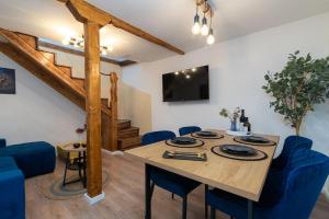 a dining room with a wooden table and blue chairs at Duplex apartment Domi in Slatine